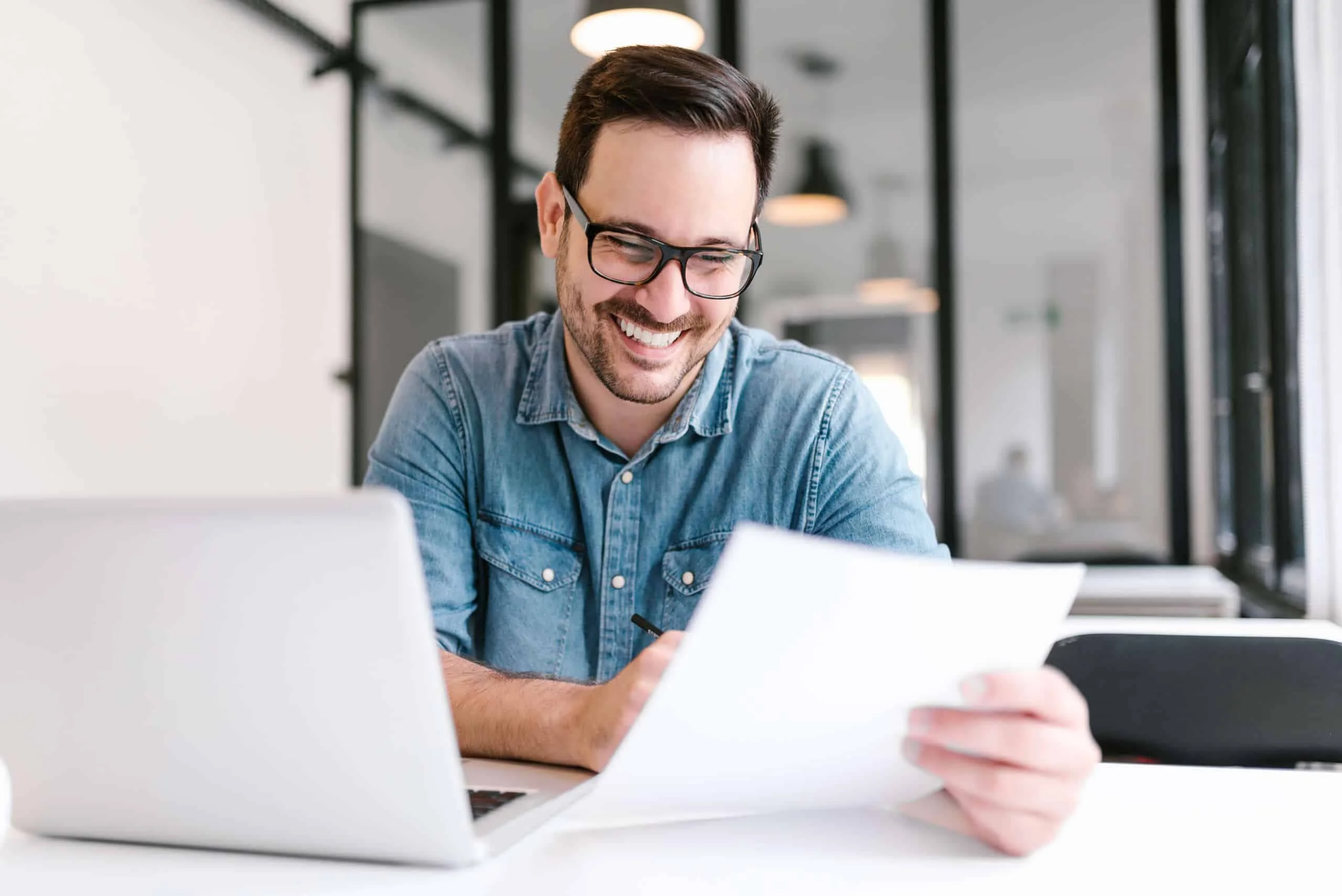 Handsome young smiling businessman working with documents.